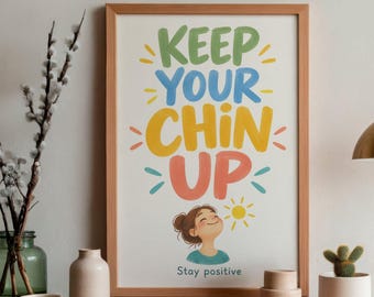 May include: A framed wall art print featuring the text KEEP YOUR CHIN UP in green, blue, yellow, and coral lettering. Below the text is an illustration of a person looking upward with a small yellow sun icon and the text Stay positive.