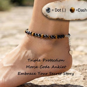 May include: A Morse code anklet featuring alternating dark grey and brown tiger eye beads on a thin chain. A small heart charm hangs from the clasp. Text on the image reads: Dot (.) = Dash (-) and Triple Protection Morse Code Anklet Embrace Your Secret Story.