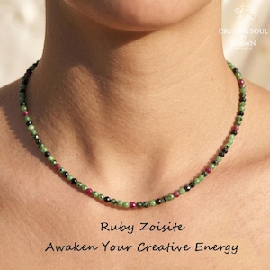 May include: A beaded necklace featuring small, faceted, round ruby zoisite stones in shades of green, black, and magenta. The text on the image reads: Crystal Soul by Shawn Artisanal, Ruby Zoisite, and Awaken Your Creative Energy.