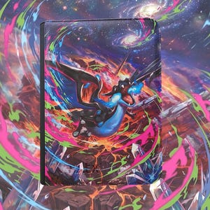 May include: A rectangular binder featuring a vibrant illustration of a black and blue dragon breathing fire amidst a cosmic space background with swirling pink, green, and blue energy streaks, rocky terrain, and crystalline structures.