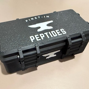 May include: A black rectangular case with the text "FIRST-IN" and "PEPTIDES" in white. The case has a textured surface and a white anvil logo. The case is closed with black latches.