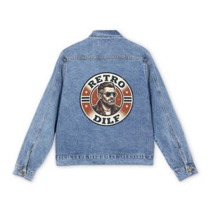 Puede incluir: Chaqueta vaquera azul claro con cierre de botones y cuello. La parte trasera presenta un gráfico circular con el texto "RETRO DILF" y una ilustración de un hombre con gafas de sol.