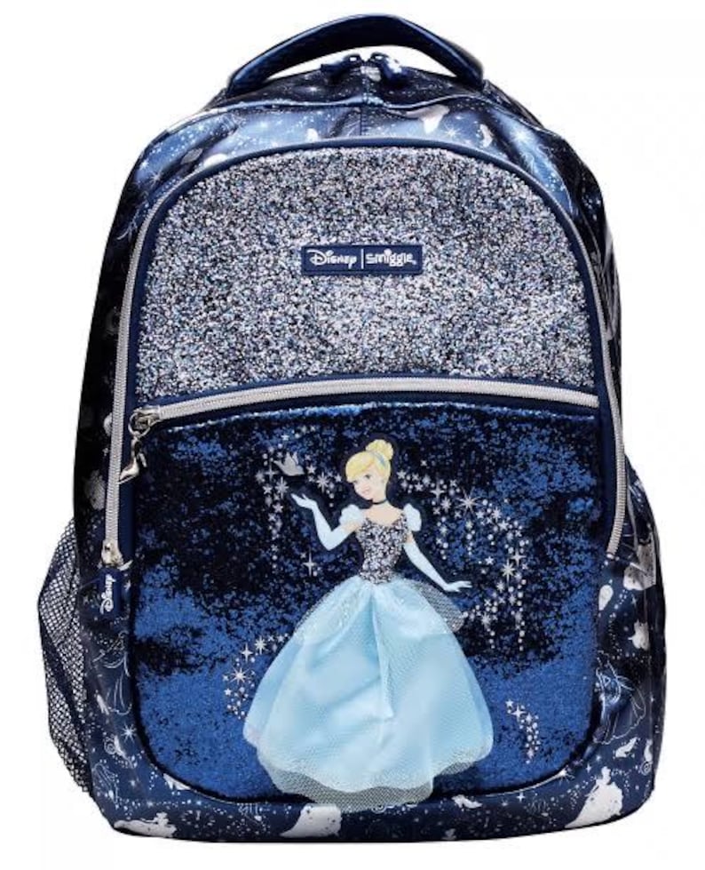 May include: A dark blue Disney Smiggle backpack featuring a glittery silver top pocket and a central compartment with a graphic of Cinderella. The bag includes a mesh side pocket, silver zippers, and a repeating white pattern of carriages and shoes.