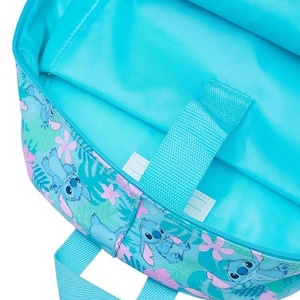 Puede incluir: Un interior de mochila de color turquesa brillante con un patr&oacute;n repetitivo de personajes Stitch azules, flores de hibisco rosas y hojas tropicales verdes. La bolsa incluye una funda para port&aacute;til a juego con una correa de cierre de velcro.