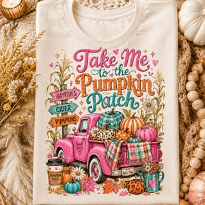 May include: A cream-colored t-shirt featuring a graphic of a pink pickup truck loaded with pumpkins. The text reads "Take Me to the Pumpkin Patch" with signs pointing to "Hayrides," "Cider," and "Pumpkins." A "Pumpkin Spice" cup and fall foliage are included.
