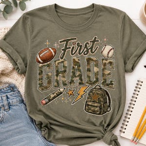 a green t-shirt with the text "First Grade" printed on it, along with various school-related items such as a football, baseball, backpack, pencils, and a notebook.