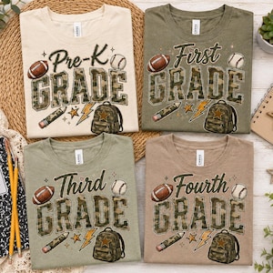 four t-shirts with the text "Pre-K Grade" printed on them, along with various sports-related icons such as a football, baseball, and backpack. The t-shirts are arranged on a table, along with a notebook, pencils, and a plant.