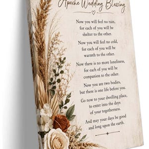 May include: A rectangular canvas print featuring the Apache Wedding Blessing text in black script and serif fonts. The left side displays a vertical arrangement of dried pampas grass, palm leaves, and cream and rust-colored roses on a beige background.