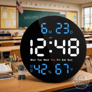 May include: A round black digital wall clock with a large white LED display showing the time 12:48. The screen features blue text for the date 6M 23D, the day of the week with Thu highlighted, a humidity level of 42%, and a temperature of 67°F.