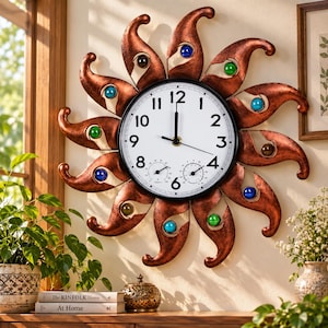 May include: A sun-shaped wall clock with a metallic copper finish and curved rays. The white clock face features black numerals, two small circular gauges for humidity and temperature, and blue and green glass accents embedded in the rays.