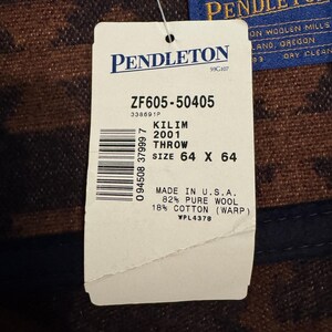 May include: A tag for a Kilim throw, size 64 x 64 inches, made in the U.S.A. The tag includes the brand name Pendleton and details about the material composition: 82% pure wool and 18% cotton.