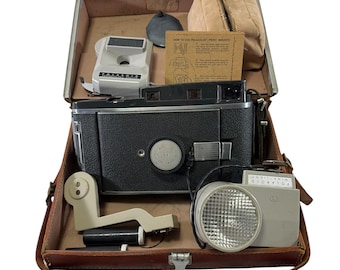 Cámara Polaroid 150 Land y unidad de flash Wink Light con estuche rígido, estilo vintage de los años 50.