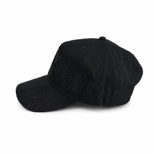 May include: A black baseball cap featuring tonal embroidery on the front panel and a subtle flame pattern stitched onto the curved brim. The cap has a structured crown with ventilation eyelets and a button at the top, all in a matching black fabric.