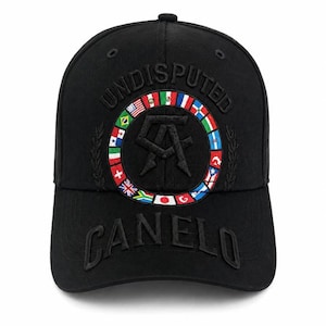 Könnte beinhalten: Eine schwarze Baseballkappe mit dem in Schwarz gestickten Wort UNDISPUTED über einem kreisförmigen Emblem aus verschiedenen internationalen Flaggen. In der Mitte des Emblems befindet sich ein schwarzes CA-Logo und auf dem Schirm ist CANELO gestickt.