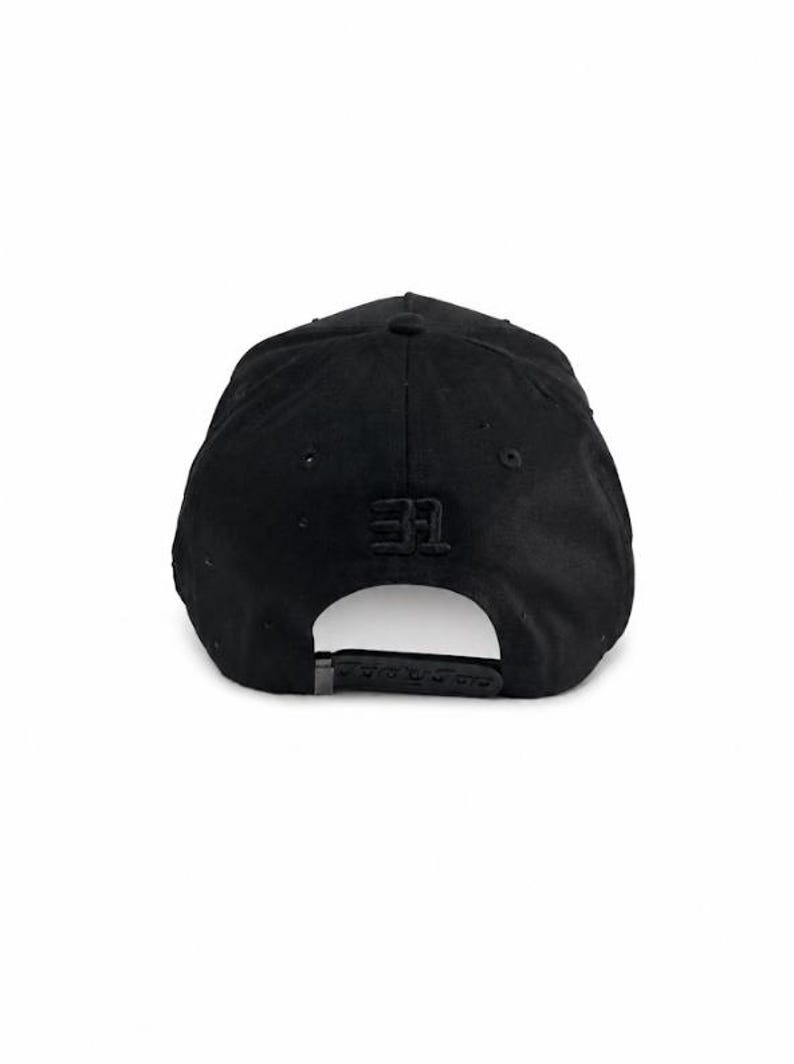 May include: A solid black baseball cap featuring a structured crown and a curved brim. The back of the cap displays the number 31 embroidered in black thread above an adjustable snapback closure, which is also black and made of plastic.