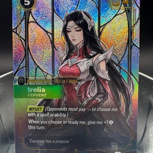 May include: A holographic trading card featuring the character Irelia from Ionia. The card displays a stained-glass background, the text Irelia Fervent, a cost of 5, and the ability Deflect. The card includes the quote Everyone has a purpose.