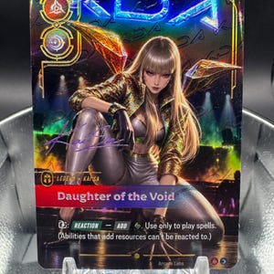 Könnte beinhalten: Eine holografische Sammelkarte mit einer blonden Figur in goldener Jacke und silberner Hose, betitelt Daughter of the Void. Die Karte zeigt den Text Legend Kaisa, Reaction, Add und Spielanweisungen, mit Arcade Labs am unteren Rand.