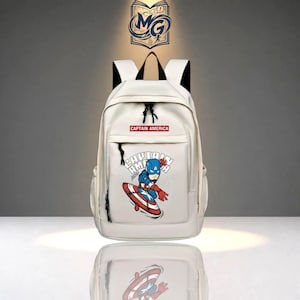 May include: A white backpack featuring a graphic of Captain America with a shield on the front pocket. The text "CAPTAIN AMERICA" is printed in a red rectangular box above the graphic. The bag has black straps and black zipper pulls.