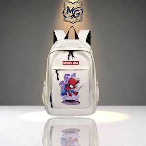 Puede incluir: Una mochila blanca con una etiqueta rectangular roja con el texto SPIDER MAN en letras blancas. Debajo de la etiqueta hay un gr&aacute;fico de un personaje de Spider-Man en rojo y azul, sobre una silueta de ciudad de color p&uacute;rpura.