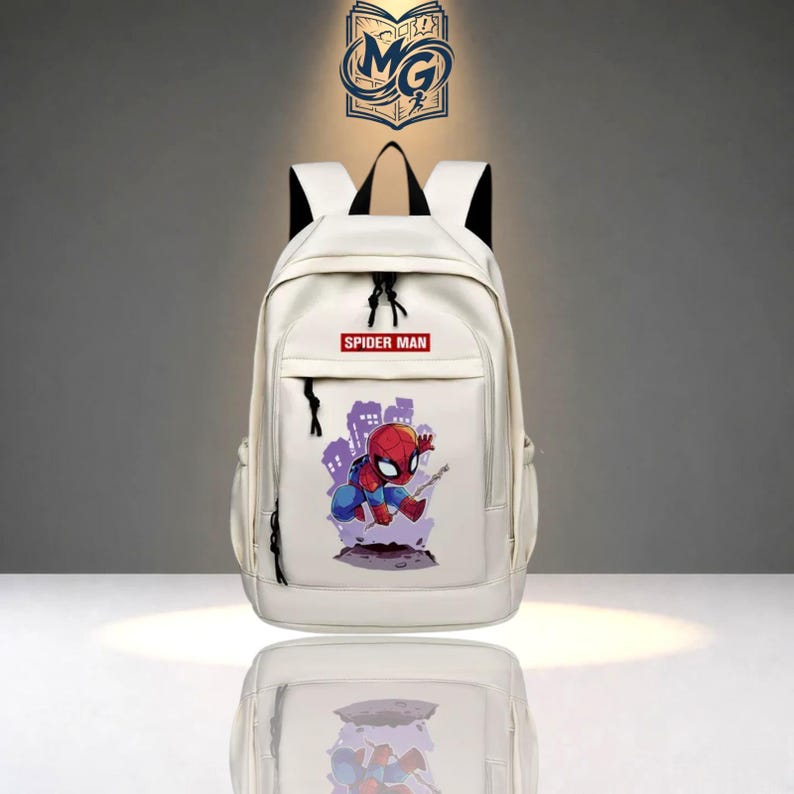 Puede incluir: Una mochila blanca con una etiqueta rectangular roja con el texto SPIDER MAN en letras blancas. Debajo de la etiqueta hay un gr&aacute;fico de un personaje de Spider-Man en rojo y azul, sobre una silueta de ciudad de color p&uacute;rpura.