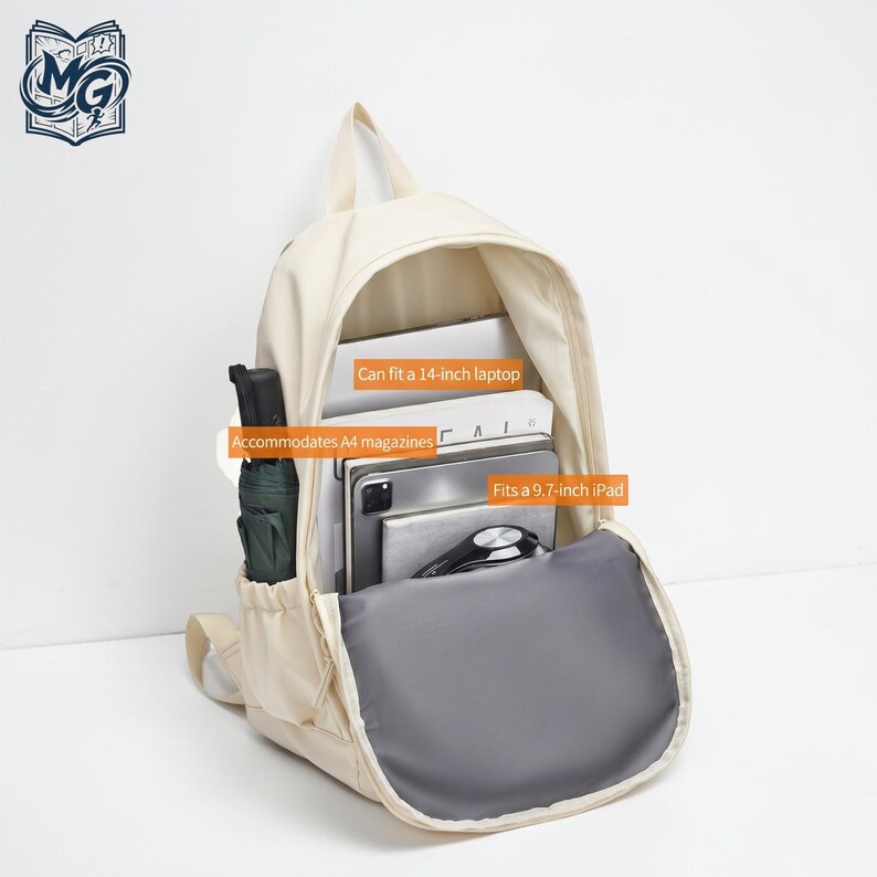 Puede incluir: Una mochila de color crema con un compartimento principal abierto que contiene un port&aacute;til de 14 pulgadas, revistas A4 y un iPad de 9,7 pulgadas. Un paraguas verde oscuro est&aacute; en el bolsillo lateral. El interior tiene etiquetas de texto naranja.