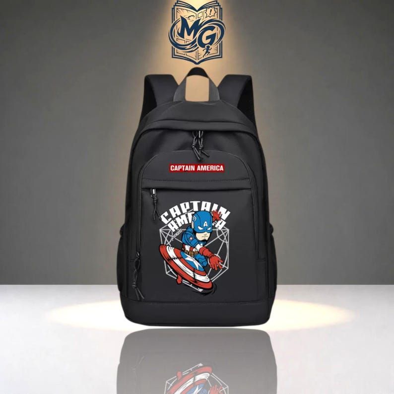 May include: A black backpack featuring a graphic of Captain America with a shield on the front pocket. The text CAPTAIN AMERICA is printed in white on a red rectangular background above the graphic. A logo with the letters MG is at the top.