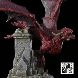 Peut inclure: Une figurine de dragon rouge avec des écailles texturées, de grandes ailes et des cornes incurvées, perchée sur une base en pilier de pierre grise patinée. La base présente des détails architecturaux et le texte Pavale Games est visible.