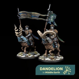 Op de afbeelding: Twee miniatuurfiguren van gepantserde ruiters op grote, ruige berggeiten met hoorns. Elke ruiter draagt een metalen harnas en een helm en draagt een hoge banier met ingewikkelde blauwe en gouden geometrische patronen. De basis is besneeuwd.