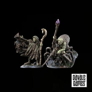 Könnte beinhalten: Zwei Fantasy-Miniaturfiguren von Davale Games. Eine ist eine grünhäutige Figur mit Kapuze, die einen Stab hält, aus dessen Umhang Fledermäuse hervorkommen. Die andere ist ein grünhäutiges Wesen auf einer großen Spinne mit einem violetten Kristallstab.