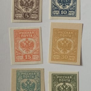 May include: A collection of six rectangular postage stamps featuring the double-headed eagle emblem and the text "РУССКАЯ ПОЧТА". The stamps are printed in brown, blue, orange, gold, teal, and green with denominations of 5, 10, 15, 30, 50, and 75 kop.