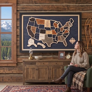 May include: A large, framed wooden wall map of the United States featuring individual state cutouts in varying wood tones mounted on a dark blue background. The map includes a compass rose emblem and is displayed above a wooden sideboard cabinet.