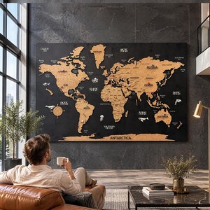 Könnte beinhalten: Eine große rechteckige Weltkarte für die Wand mit Kontinenten aus Kork auf einem einfarbigen schwarzen Hintergrund. Die Karte zeigt beschriftete Ozeane, Länder und Kontinente mit verschiedenen bunten Pinnadeln an bestimmten Orten.