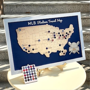 May include: A framed wooden map of the United States titled MLB Stadium Travel Map, featuring cutouts for stadium locations. It includes a separate rectangular board with circular team logos and a decorative baseball and bat emblem labeled Terry's Stadium Map.
