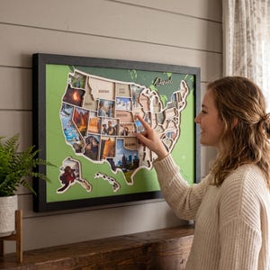 May include: A framed wall map of the United States featuring individual wooden state cutouts, each containing a unique photograph. The map is set against a green background with grid lines, and the name Daniel is written in script at the top right.