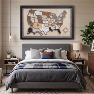 May include: A large, framed, multi-layered wooden wall map of the United States featuring individual state cutouts in varying shades of natural wood, brown, and gray, with engraved state names and icons, mounted on a light wood backing board.