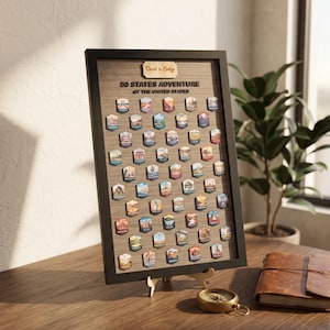 May include: A rectangular black-framed wall art piece titled 50 STATES ADVENTURE OF THE UNITED STATES, featuring a wood-grain background and fifty small, hexagonal, colourful state-themed icons arranged in rows, with a custom name plaque at the top.