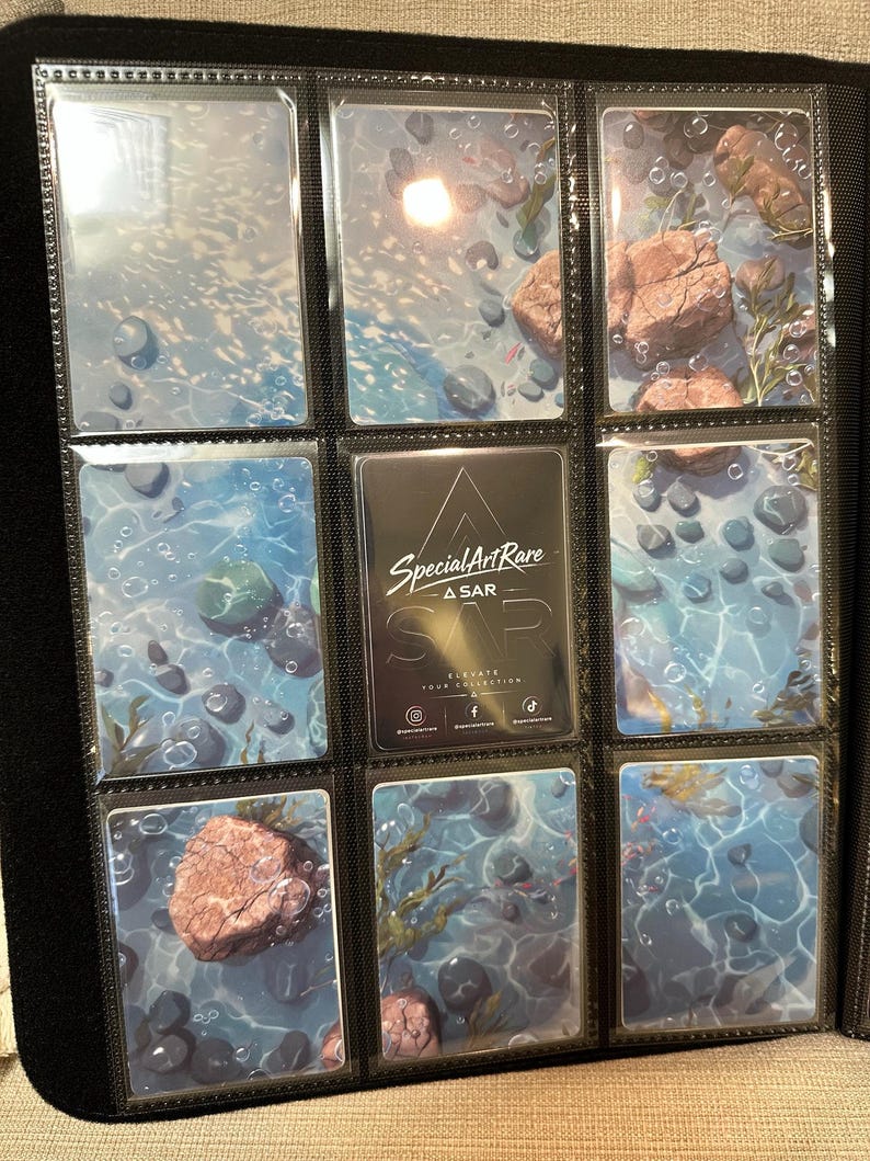 May include: A black trading card binder page containing nine rectangular cards. Eight cards feature a blue water scene with rocks and bubbles. The centre card is black with white text reading Special Art Rare A SAR Elevate Your Collection.