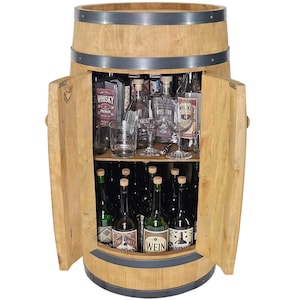Può includere: Un mobile bar in legno color marrone chiaro a forma di botte con due ante aperte e due ripiani interni. Il ripiano superiore contiene bottiglie di vetro etichettate Whisky e bicchieri. Il ripiano inferiore contiene bottiglie con etichette Wein.
