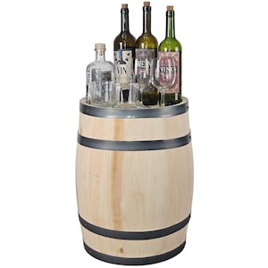 Può includere: Un barile in legno chiaro con quattro fasce metalliche scure. La superficie superiore ospita tre bottiglie di vino in vetro con etichette recanti le scritte VIN, WEIN e VINO, un decanter in vetro trasparente e due bicchieri in vetro.