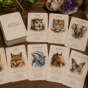 Può includere: Un mazzo di carte oracolo Animal Wisdom con una scatola e un mazzo di carte che presentano illustrazioni ad acquerello di animali tra cui lupo, gufo, tigre, elefante, cervo, volpe, delfino, cavallo e farfalla, con testo descrittivo e riflessioni.