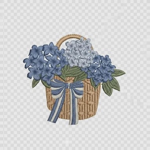 May include: An embroidered design of a tan woven basket filled with clusters of blue and light blue hydrangea flowers and green leaves. A decorative blue and white striped ribbon is tied in a bow around the front of the basket handle.
