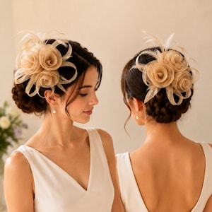May include: A beige fascinator hair accessory featuring three circular mesh rosettes and delicate upright feathers. The piece is constructed from a stiffened, woven fabric with a structured, looped design, providing a layered appearance that sits atop the hair.