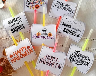Könnte beinhalten: Eine Sammlung von Knicklichtern mit befestigten quadratischen Papierkarten, die verschiedene Halloween-Motive und Texte wie Happy Halloween und Sübes sonst gibt's Saures zeigen, mit bunten Neon-Kunststoffstäben.