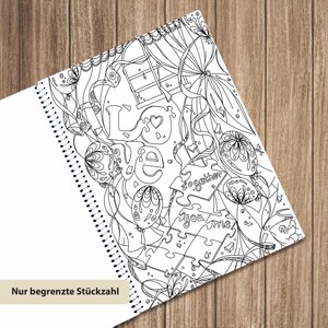 May include: A spiral-bound coloring book page featuring black and white line art with the word LOVE, puzzle pieces labeled together and you me, balloons, and ribbons. The design includes intricate patterns and a window motif for coloring.