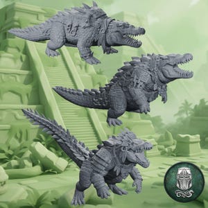 Op de afbeelding: Drie grijze miniatuurfiguren van krokodillen in dynamische houdingen, elk versierd met ingewikkeld uitgesneden harnassen en hoofdtooien. De figuren hebben getextureerde schubben, open bekken met zichtbare tanden en gedetailleerde riemen over hun lichamen.