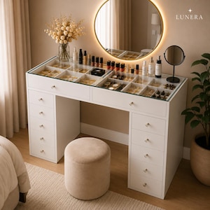 May include: A white vanity desk with a glass top, featuring multiple storage drawers, a round LED-lit mirror, and a matching beige upholstered stool. The desk surface displays various cosmetics and jewelry. The text LUNERA is visible.