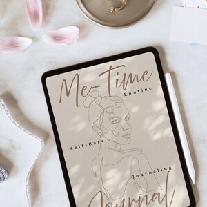 Könnte beinhalten: Ein digitales Tablet mit einem Journal-Cover mit dem Text "Me-Time Routine, Self-Care, Journaling". Das Cover zeigt eine Strichzeichnung eines Frauengesichts. Goldene Ohrringe und ein Tablett befinden sich im Hintergrund.