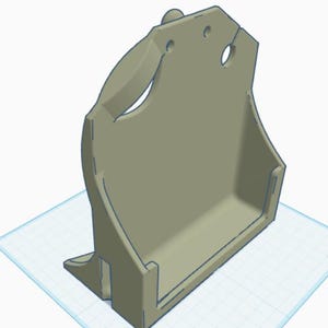 May include: A light gray, three-dimensional computer-generated model of a wall-mounted storage holder. The object features a flat back panel with two circular mounting holes at the top and a deep, rectangular tray base for holding items securely.
