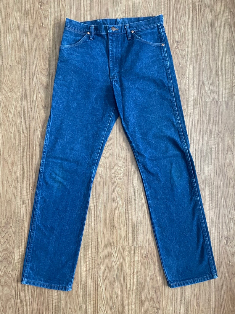 May include: A pair of dark blue denim jeans with a straight leg fit.