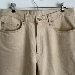 May include: A pair of light beige denim jeans with a classic five-pocket style.
